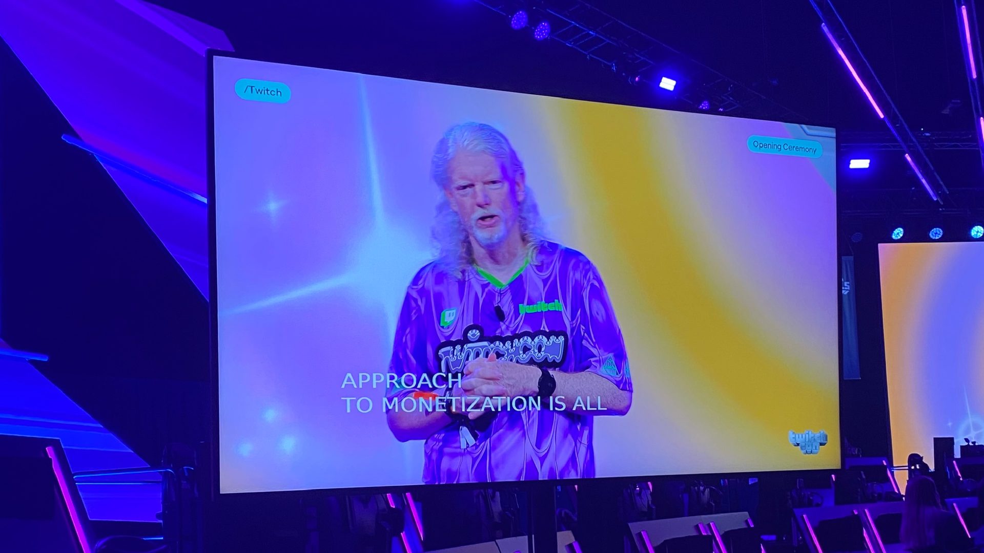 Foto van een tv scherm met daarop Dan Clancy, de CEO van Twitch, met ondertiteling. Ondertiteling is niet geweldig goed te lezen en had een achtergrondje achter gemogen.